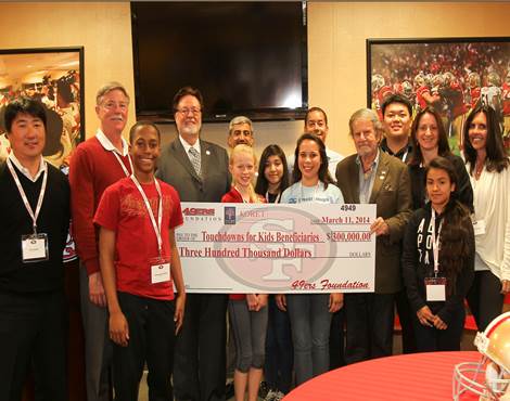 Touchdowns for Kids co-founders Tad Taube and John York present the $300,000.00 check to the benefitting organizations on March 11.