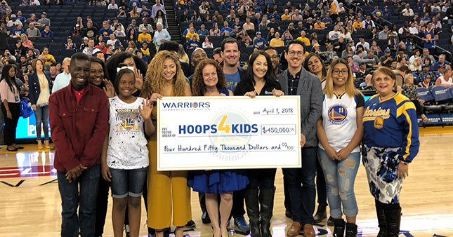 L to R holding the check: Rachel Wyley (Playworks), Joanne Pasternack (Warriors Community Foundation), Sean Taube (Taube Philanthropies), Stephanie Isaacson (PG&E), and Kyle Marinshaw (Koret Foundation); together with other beneficiaries. 